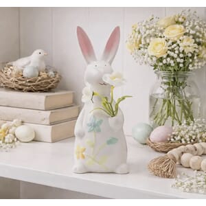Figur kanin holder hvit blomst påske